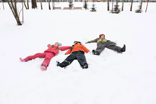 Glückliche Kinder im verschneiten Park im Winterurlaub — Stockfoto