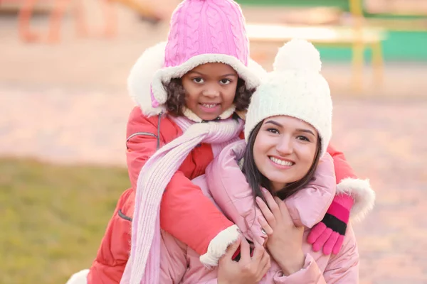 Mujer joven con una niña afroamericana al aire libre. Adopción infantil —  Fotos de Stock
