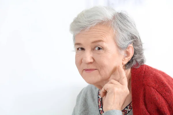 Reife Frau mit Hörgerät im Haus — Stockfoto