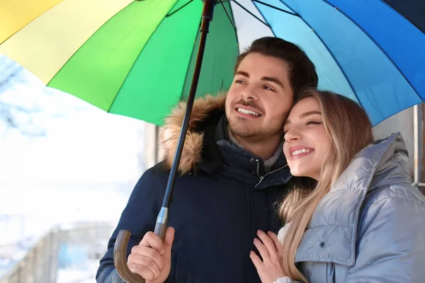 Young romantic couple with colorful umbrella outdoors — Stock Photo, Image
