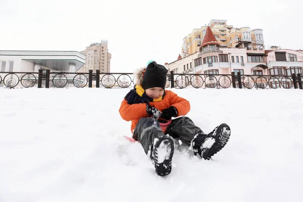 Netter Junge hat Spaß im verschneiten Park im Winterurlaub — Stockfoto