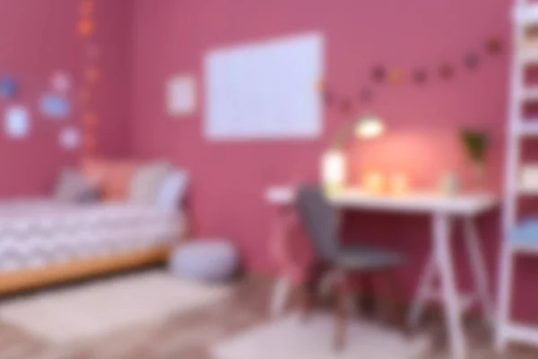 Розмитий вид на зручне ліжко і стіл в сучасній дитячій кімнаті — стокове фото