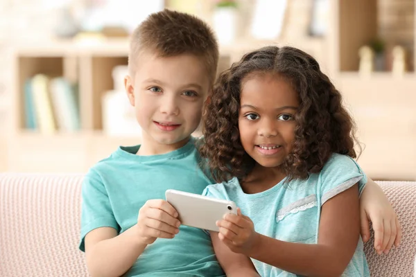 Bambini carini con smartphone all'interno. Adozione dei bambini — Foto Stock