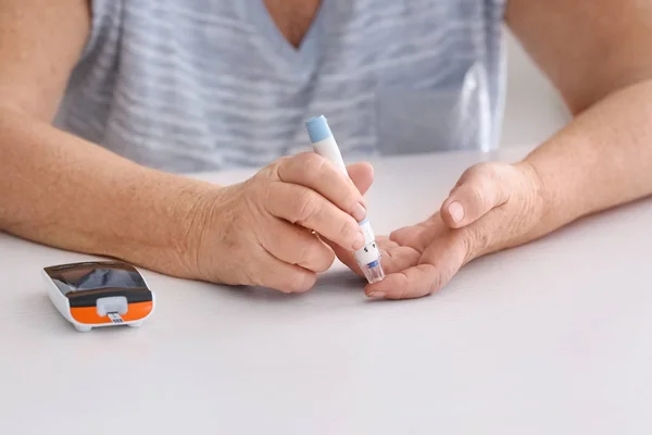 Femme âgée diabétique mesurant le taux de sucre dans le sang à domicile, gros plan — Photo