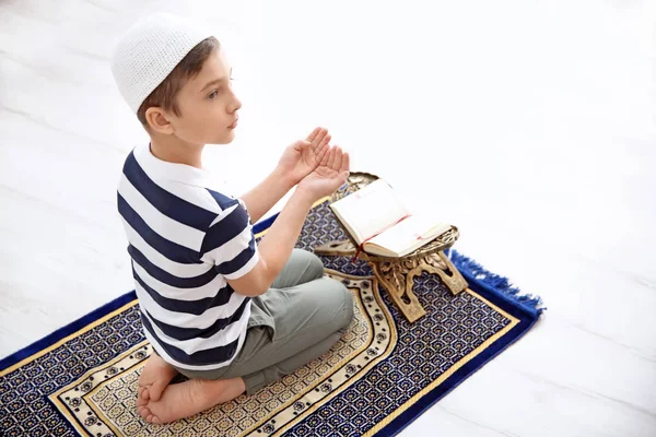 Niño musulmán rezando en la alfombra en casa — Foto de Stock