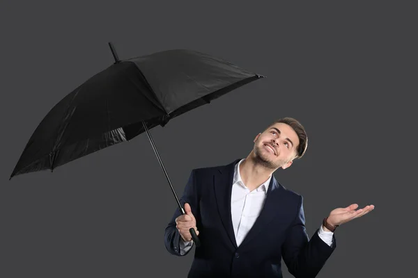 Junger Mann im eleganten Anzug mit Regenschirm — Stockfoto