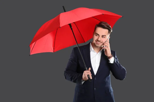 Joven con paraguas rojo hablando por celular —  Fotos de Stock