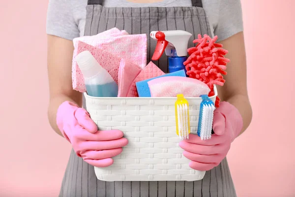 Mulher segurando cesta com suprimentos de limpeza — Fotografia de Stock