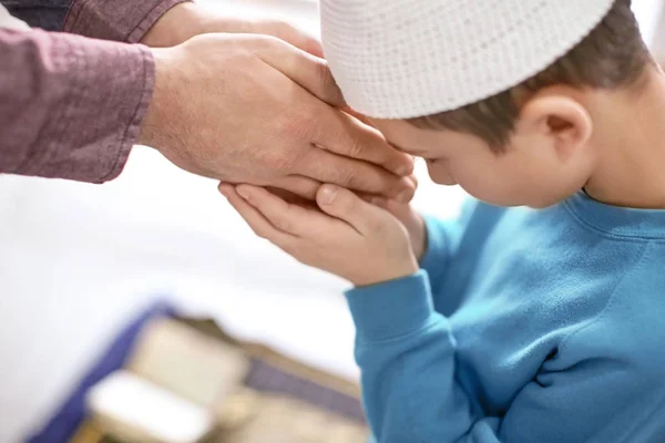 Мусульманский отец и сын молятся вместе, в помещении — стоковое фото