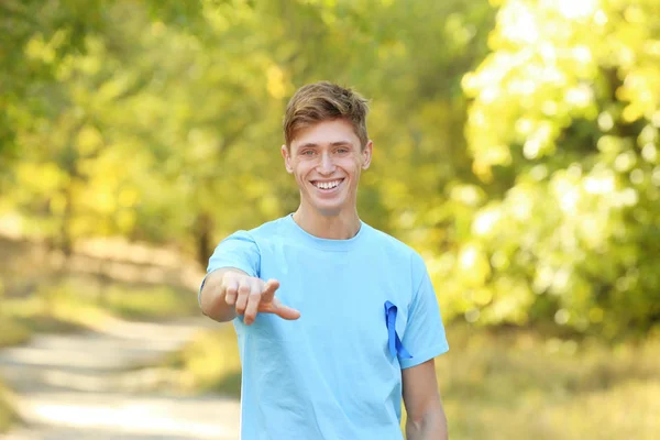 年轻男子在 t-shirt 与蓝丝带户外。前列腺癌认知概念 — 图库照片