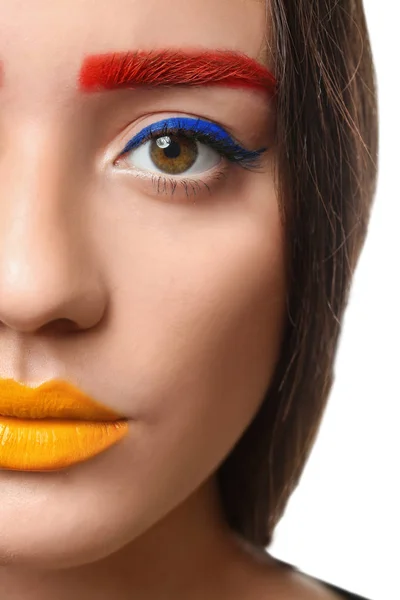 Ung kvinde med farvede øjenbryn og kreativ makeup på hvid baggrund, closeup - Stock-foto