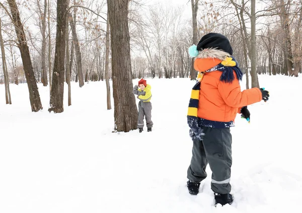 Roztomilý kluci hrají v zasněženém parku na zimní dovolenou — Stock fotografie