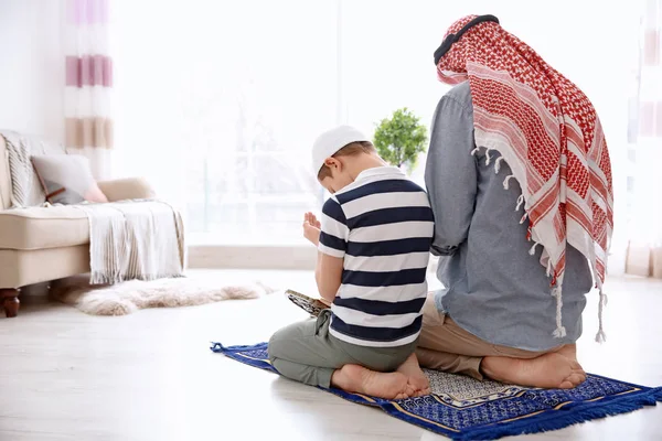 Homme musulman priant avec son fils à la maison — Photo