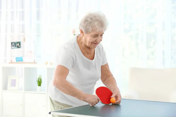 Mujer mayor jugando al tenis de mesa en interiores — Foto de Stock