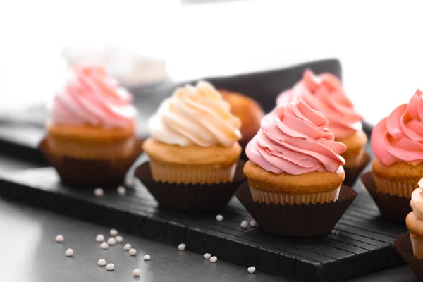 Leckere Cupcakes mit Sahne auf dem Tisch — Stockfoto