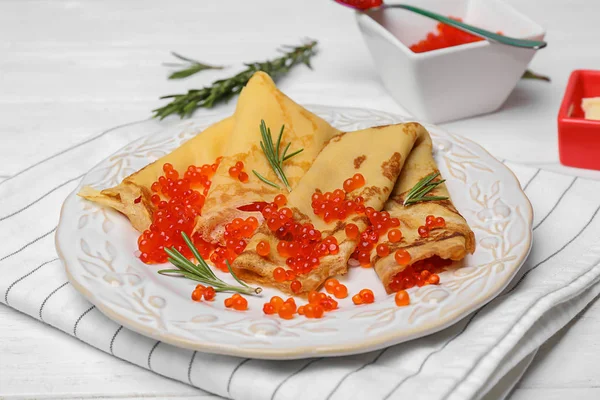 Plate with thin pancakes and red caviar on table — Stock Photo, Image