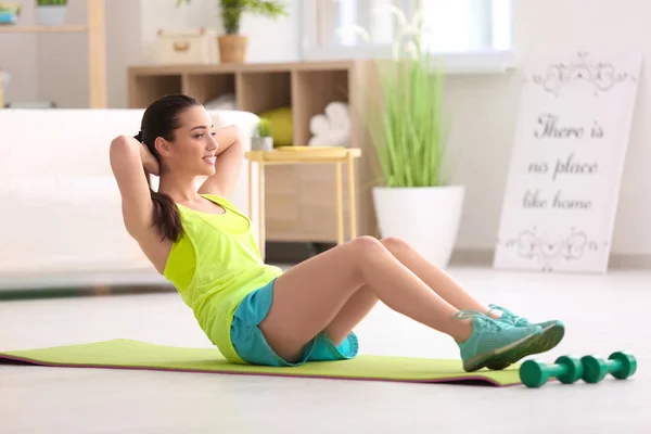 Mulher bonita fazendo exercício de fitness em casa — Fotografia de Stock
