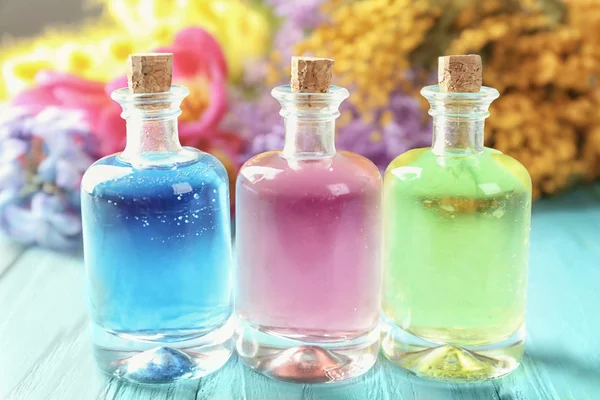 Botellas con diferentes aceites de perfume sobre mesa de madera — Foto de Stock