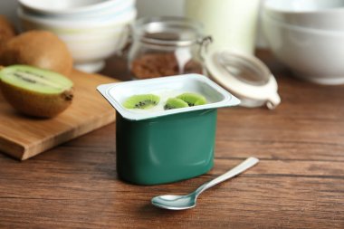 Lezzetli kivi yoğurt ahşap masa üzerinde plastik bardak