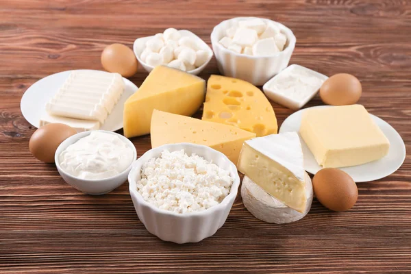 Produk susu yang berbeda dan telur di atas meja kayu — Stok Foto