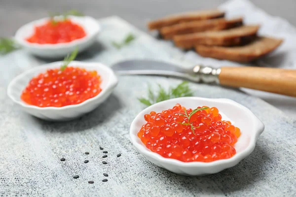 Pequeños platos con delicioso caviar rojo en la mesa —  Fotos de Stock