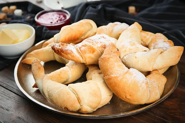 Plate with fresh tasty crescent rolls on wooden table, closeup — Stock Photo, Image