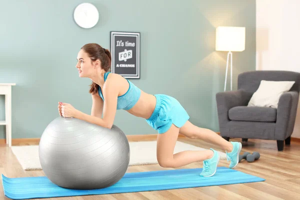 Mulher bonita fazendo exercício de fitness com bola em casa — Fotografia de Stock