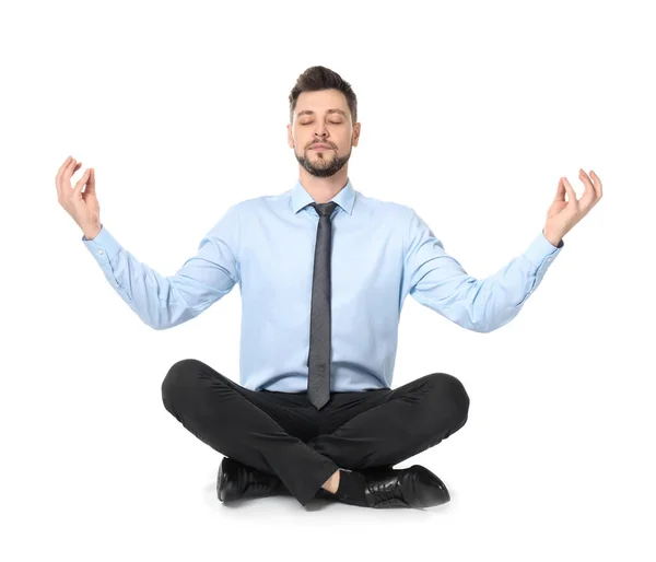 Молодой бизнесмен медитирует на белом фоне — стоковое фото