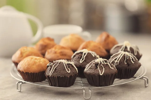 Kühlregal mit leckeren Cupcakes auf dem Tisch — Stockfoto