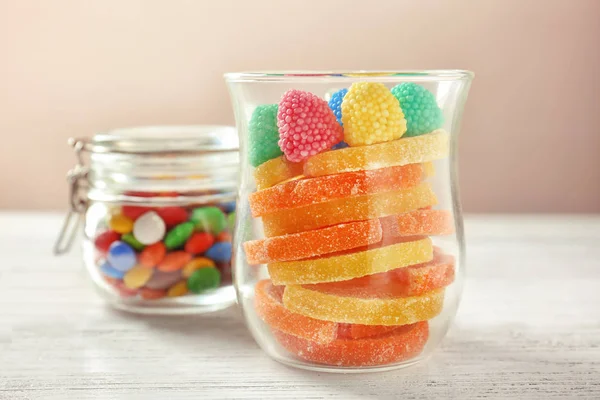 Vetreria con caramelle colorate sul tavolo sullo sfondo chiaro — Foto Stock