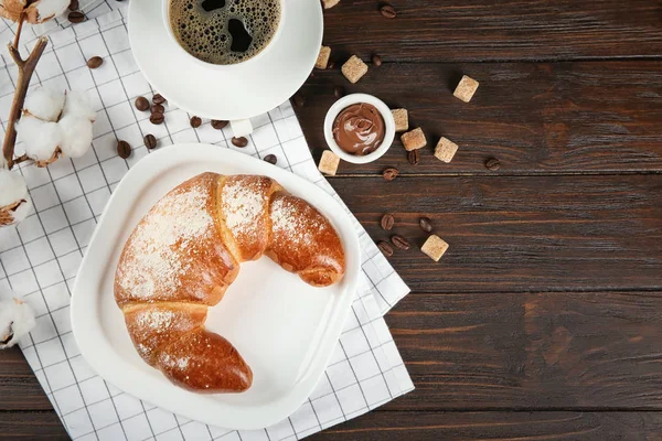 Composición con fresco rollo de media luna sabroso y café sobre fondo de madera — Foto de Stock