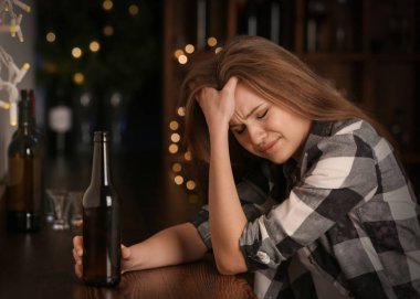 İçki şişe olan üzgün kadın çubuk. Alkolizm sorunu
