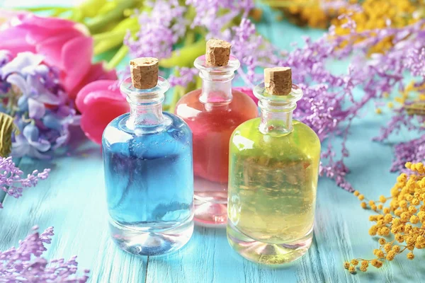 Garrafas com diferentes óleos de perfume na mesa de madeira — Fotografia de Stock