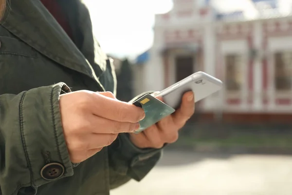 Donna con carta di credito utilizzando smartphone all'aperto — Foto Stock