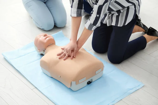 Group of people practicing CPR on mannequin at first aid class — Stock Photo, Image