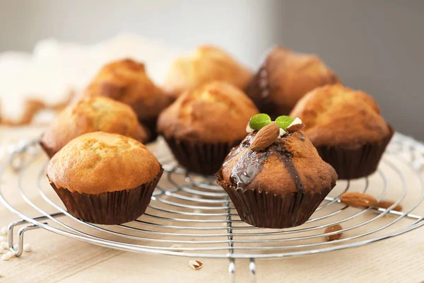Koeling rack met smakelijke cupcakes op tafel — Stockfoto
