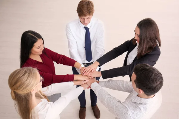 People putting hands together indoors — Stock Photo, Image