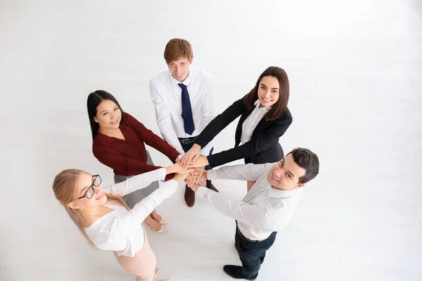 Gente poniendo las manos juntas en el interior —  Fotos de Stock