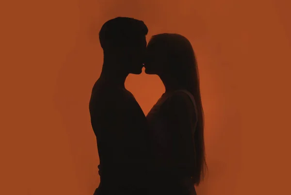 Silhuetten av unga romantiska par kyssar — Stockfoto