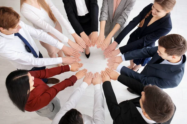 Människor sätter händerna tillsammans inomhus. Unity-konceptet — Stockfoto