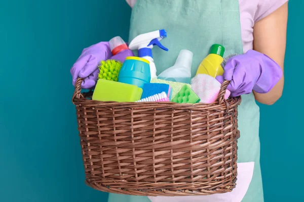 Woman holding basket with cleaning supplies Stock Photo by