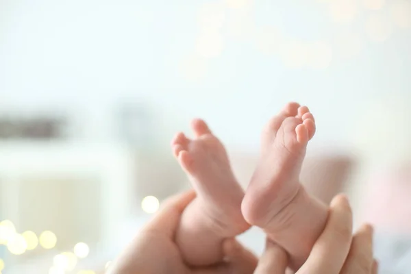 Liebevolle Mutter, die die Füße ihres Babys hält, Nahaufnahme — Stockfoto