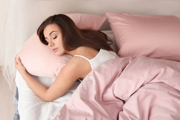 Joven mujer durmiendo en la cama — Foto de Stock