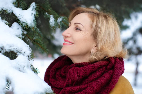 Happy mature woman in snowy park — Stock Photo, Image