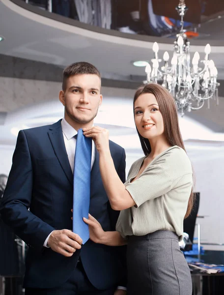 Assistente ajudando o homem a escolher terno — Fotografia de Stock