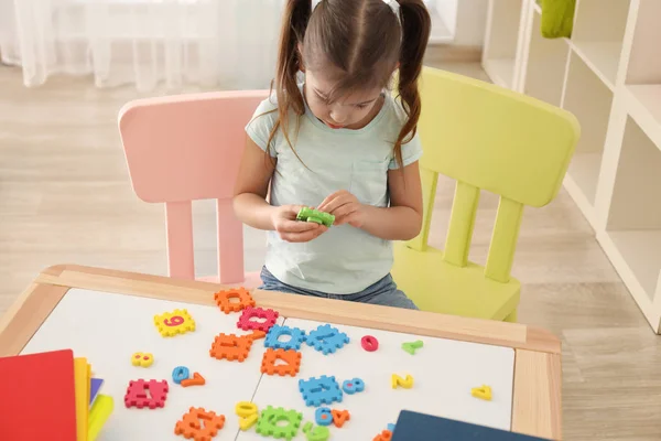 Söt liten flicka som leker med siffror — Stockfoto