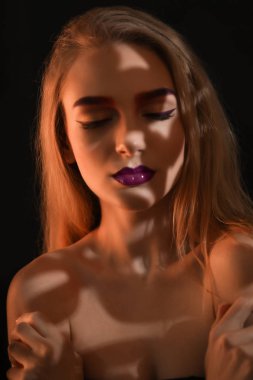 Karanlığın içinde boyalı kaşlar olan kadın