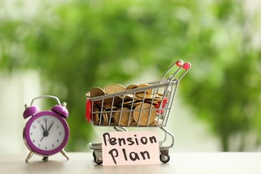 Shopping cart with coins and alarm clock on table against blurred background. Time for pension planning clipart