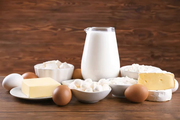 Different dairy products and eggs on wooden table — Stock Photo, Image