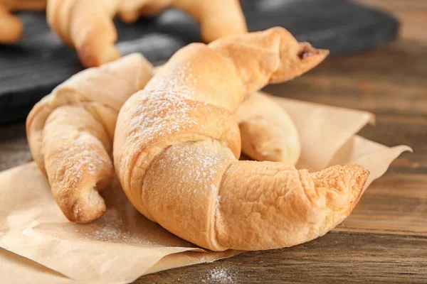 Tasty crescent rolls on wooden table — Stock Photo, Image